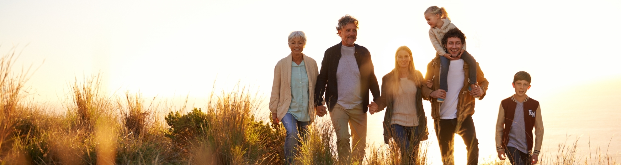 Family Walking In Field Outdoors